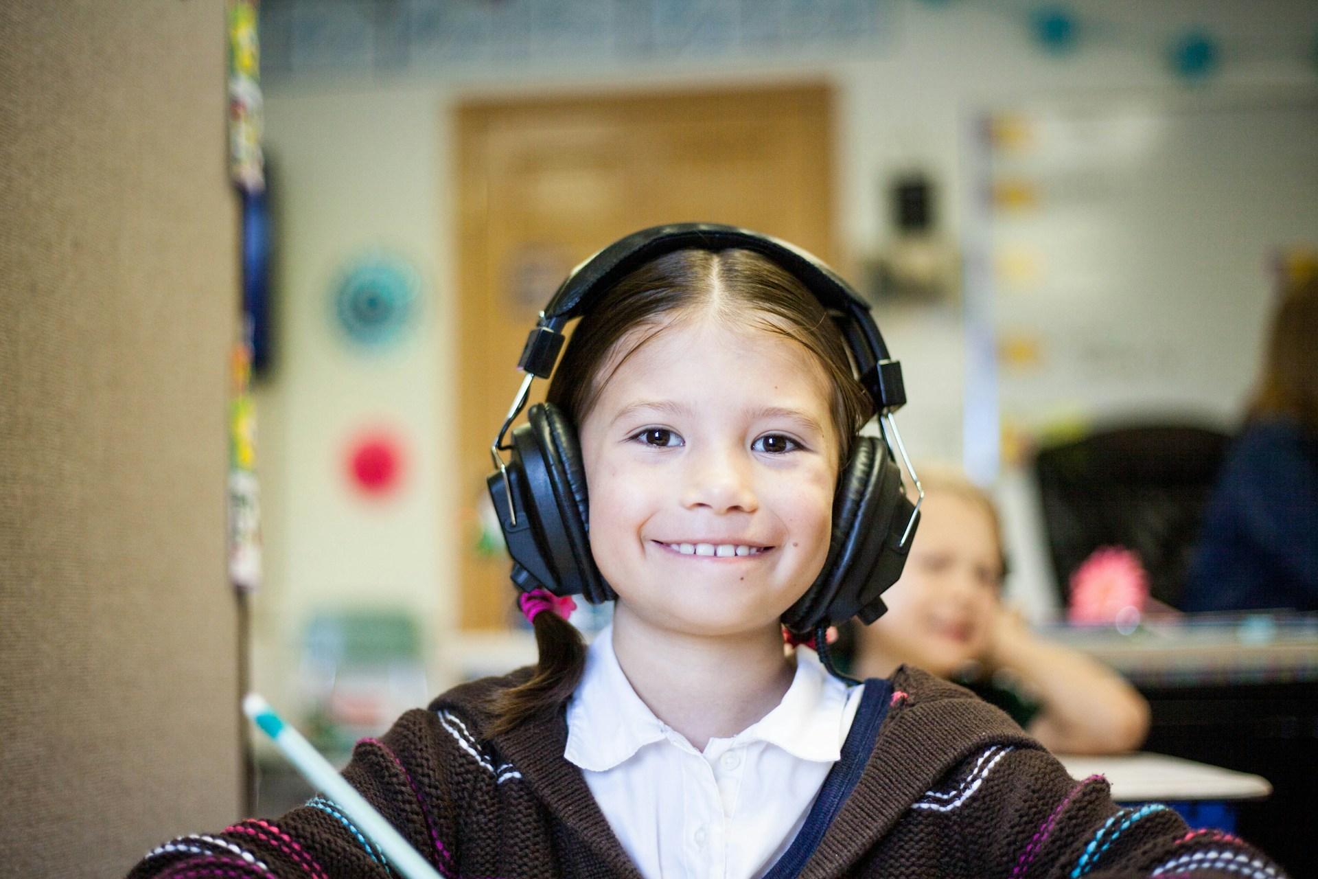 A girl with headphones sitting in class